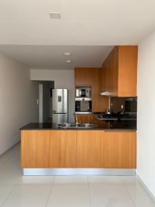 普拉亚NICE DUPLEX, PRAIA的厨房配有木制橱柜和不锈钢冰箱。