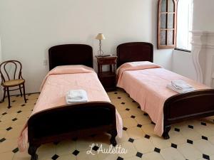 卡法亚特L' Auletta的配有两张椅子和一张桌子的房间内的两张床
