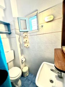 富尔尼群岛Patras Rooms est 1990的浴室配有白色卫生间和盥洗盆。