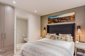斯泰伦博斯多普街107号t精品酒店的卧室配有一张大床,墙上挂有绘画作品