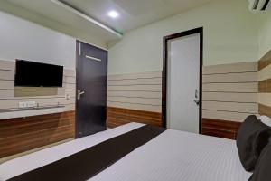 希萨尔Collection O The Legend Hotel, Hisar的一间卧室配有一张床和一台平面电视