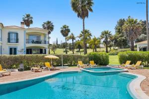 卡武埃鲁Pestana Carvoeiro Golfe - AL的一座别墅,设有游泳池和棕榈树