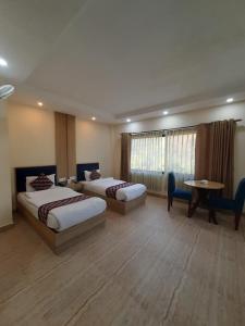 MakaisingSiddhartha Riverside Resort, Chumlingtar的酒店客房设有两张床和一张桌子。