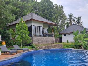 姆杜克MAYURA BALI VILLA的房屋前有游泳池的房子