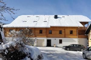 圣迈克尔隆高Stranach Appartements的一座大木屋,屋顶上积雪