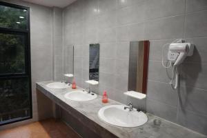 曼谷Feel good pinklao的一间带两个盥洗盆的浴室和墙上的一部电话