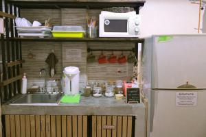 曼谷Feel good pinklao的厨房配有水槽、微波炉和冰箱