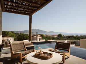 利萨基亚Pierros Verde的一个带两把椅子和一张桌子的庭院和一个游泳池