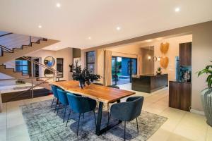 克尼斯纳Luxury Views + Excellence - Pezula no Loadshedding的一间带木桌和蓝色椅子的用餐室