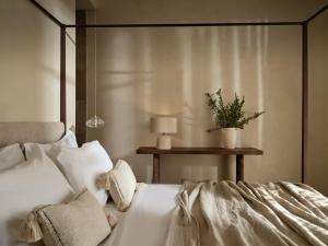 利萨基亚Pierros Verde的卧室配有白色的床和植物桌子