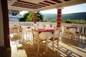 阿穆迪亚Hotel Alexandros的阳台餐厅,配有白色的桌椅