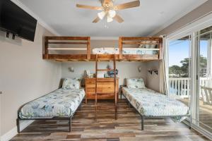 霍尔顿海滩Bird's Nest的带吊扇的客房内的两张双层床