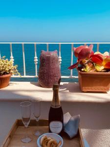 莫诺波利B&b Casa Maredentro的阳台上的桌子上摆放着一瓶葡萄酒和玻璃杯