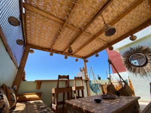 依索安Palmsurfexpo的一个带木桌和草屋顶的庭院
