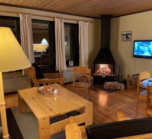 萨伦Hemfjällsbyn 17A的客厅配有桌子和壁炉