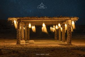 梅尔祖卡Dihya desert camp的夜晚沙漠中带灯光的木拱