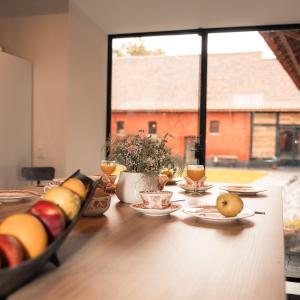 克鲁斯豪坦Lozerkasteel的餐桌,餐桌上放着盘子和窗户