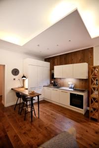 塔林Town Hall Square Apartment的厨房铺有木地板,配有白色橱柜。