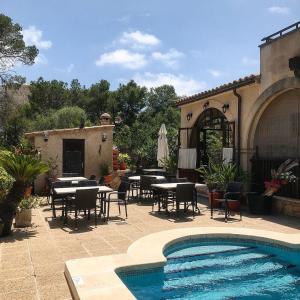 卡拉菲格拉洛伦佐别墅酒店的一个带桌椅的庭院和一个游泳池