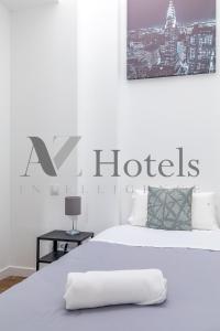 马德里AYZ Luis Cabrera-Auto check-in property的白色卧室,床上有酒店标志