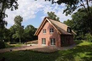 不来梅·弗格萨克Exklusives Reetdachhaus in der Bremer Schweiz的红砖房子,有 ⁇ 帽屋顶