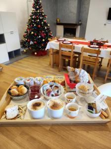 巴罗尼西Setteabbracci Suite & Apartments的圣诞树旁边的桌子上放着一盘食物
