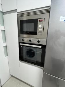 萨拉戈萨Apartamento en Zaragoza con parking的厨房里配有冰箱里的微波炉