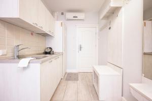 德鲁斯基宁凯阿尔特酒店的白色的厨房配有白色橱柜和水槽