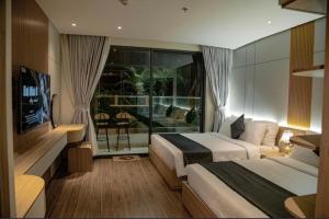绥和市Apec Mandala Sun-Condotel Phu Yen的酒店客房设有两张床和一个阳台。