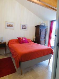 GizeuxLe Petit Pré, Gîte chez l'habitant的一间卧室配有一张带红色毯子的床