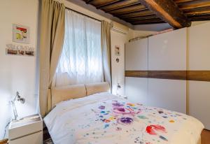 佛罗伦萨Haggi’s Residence的一间卧室设有一张床,窗户上装有鲜花