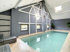 TaillesThe Lodge Ardenne的蓝色墙壁的房间内的游泳池