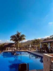 圣希尔Hotel Campestre Palmas del Zamorano的度假酒店内带桌椅的游泳池