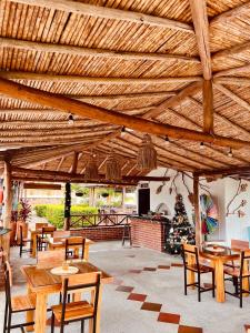 圣希尔Hotel Campestre Palmas del Zamorano的凉亭,配有木桌和椅子,还有圣诞树