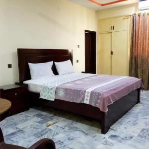 卡拉奇Hotel Sky Inn Clifton的一间卧室,卧室内配有一张大床