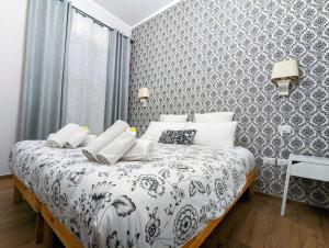 萨莱诺gia'Notte BB Salerno Centro by ElodeaGroup的一间卧室配有一张带黑白毯子的床