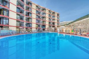圣巴托洛梅Suite Guinea 506 by Homestaygrancanaria的大楼前的大型游泳池