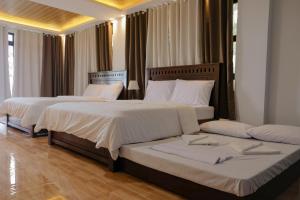 帕古普Saffire Beach Resort and Glamping的配有白色床单的酒店客房内的两张床