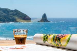 阿齐欧斯·贡多斯丽都索非亚公寓式酒店的坐在海边的桌子上喝杯啤酒