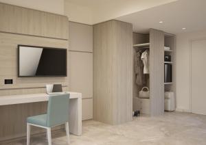西尔米奥奈假日公寓酒店的客房设有书桌、椅子和电视。