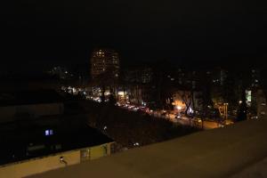 地拉那Cozzy Loft-Blloku Downtown的汽车在夜间欣赏城市美景