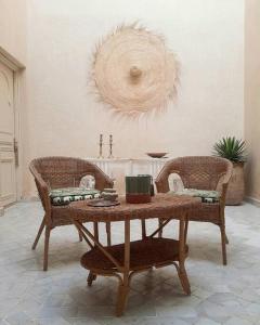 马拉喀什Riad Nour, Maison de charme.的客厅配有桌子和两把椅子