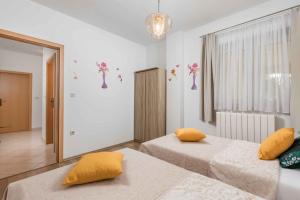 克拉列维察Two-Bedroom Apartment in Kraljevica II的一间卧室配有两张带黄色枕头的床