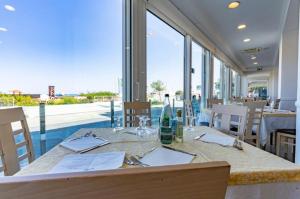 卡托利卡贝尔维尤酒店的一间带桌子和大窗户的用餐室