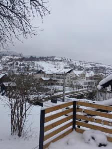 BorsaAlissa House的雪覆盖的长凳,有房子的背景