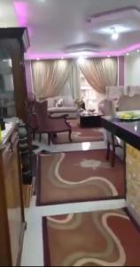 Qaryat ash Shamālīشقة فندقية的厨房以及带沙发和桌子的客厅。