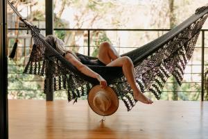 南圣胡安TreeCasa Hotel & Resort Nicaragua的坐在吊床上戴帽子的女人