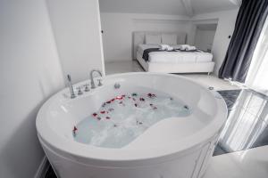 奥赫里德Delago的配有床铺的客房内的白色浴缸
