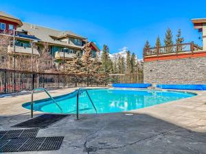 坎莫尔Canmore Mountain view loft apartment heated outdoor pool的一个带围栏的院子内的游泳池