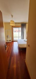波尔图Azulejos Apartment的一间卧室设有一张床和一个大窗户